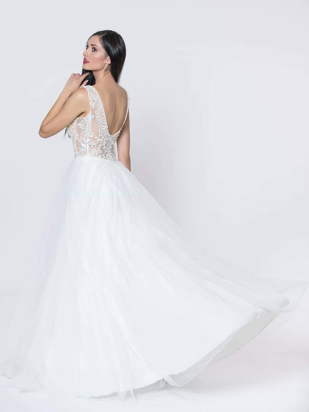 Εντυπωσιακό νυφικό με ολοκέντητο μπούστο με πέρλες και swarovski, με διαφάνεια soleil και ανοιχτή πλάτη.  Φούστα από μεταξωτό τούλι.