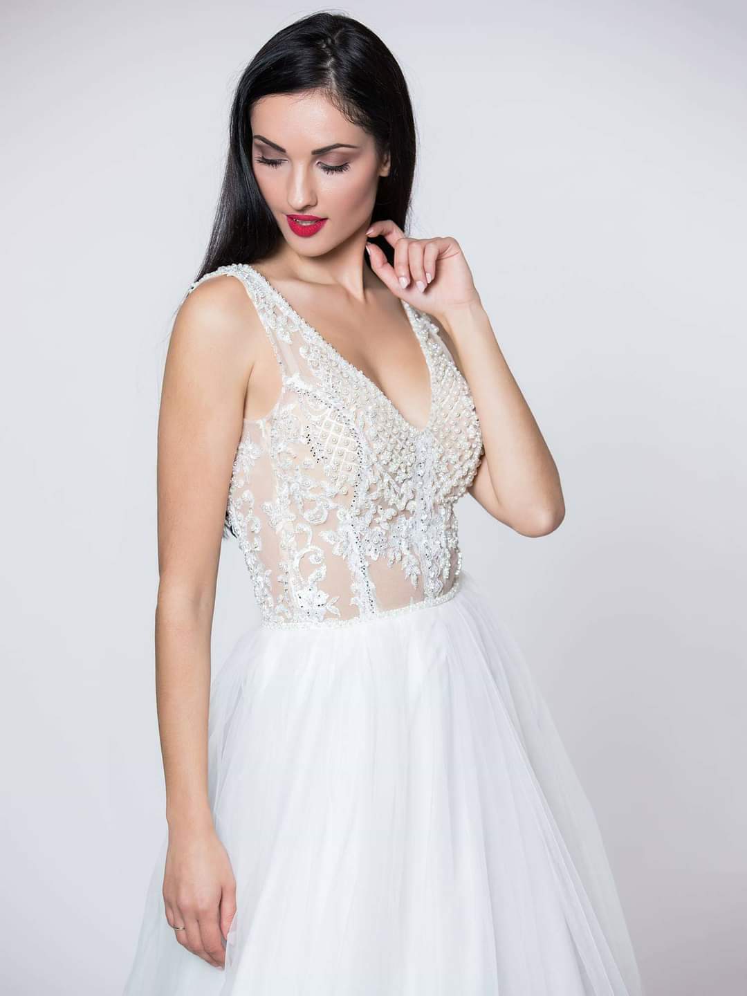 Εντυπωσιακό νυφικό με ολοκέντητο μπούστο με πέρλες και swarovski, με διαφάνεια soleil και ανοιχτή πλάτη.  Φούστα από μεταξωτό τούλι.