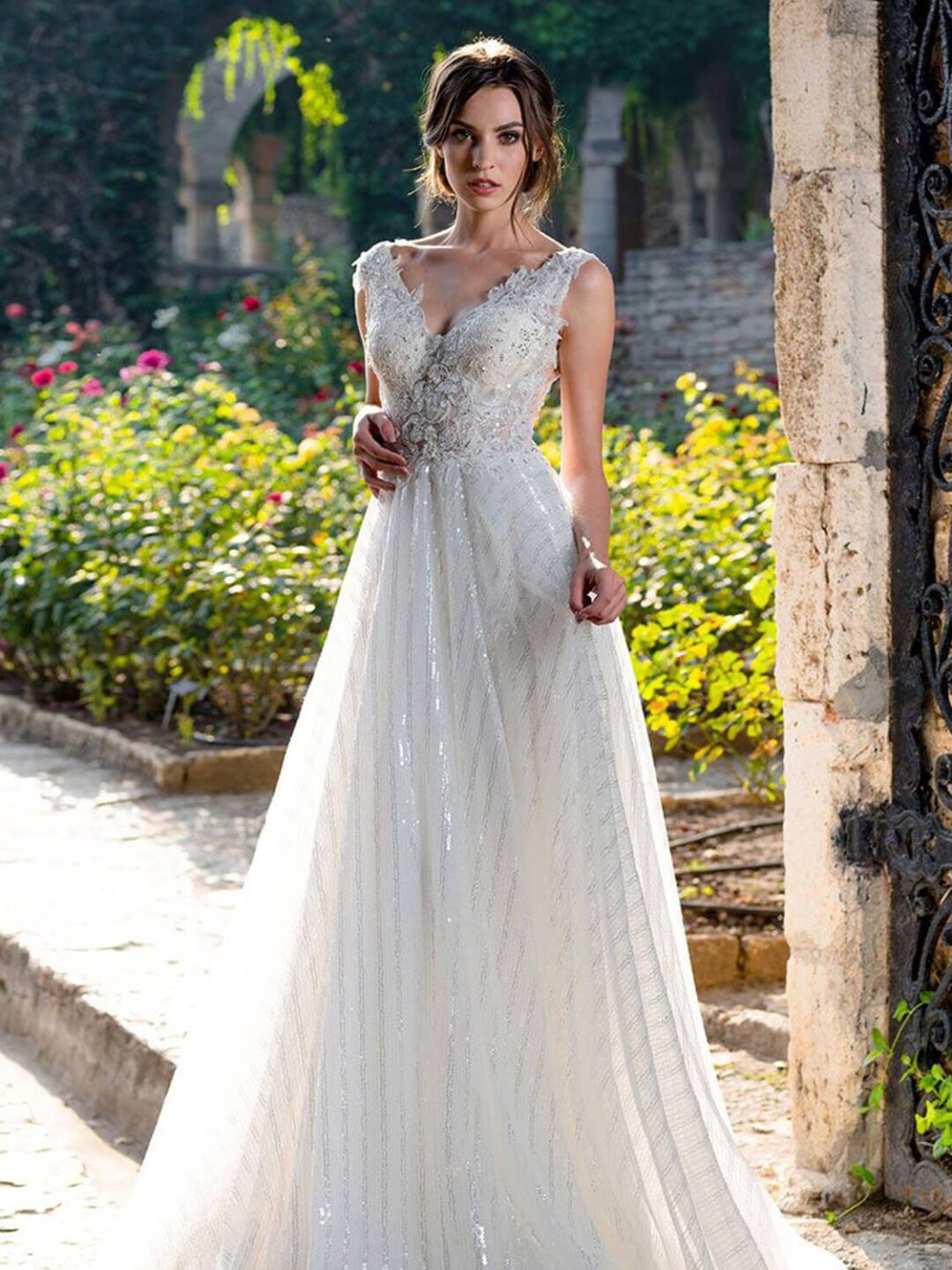 Πριγκηπικό νυφικό σε Άλφα γραμμή με  μπούστο κεντημένο με  υπέροχη γαλλική δαντέλα, διακοσμημένο με στρας και φούστα από γαλλικό τούλι με ρίζες ασημί για λάμψη . Μπούστο V με δαντέλα που αγκαλιάζει όμορφα τον ώμο