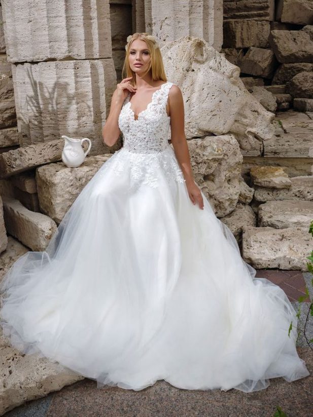 Ρομαντικό νυφικό σε Άλφα γραμμή, με φούστα από γαλλικό τούλι και κεντημένη δαντέλα κάτω από τη μέση. Με υπέροχο ολοκέντητο μπούστο με γαλλική δαντέλα που καταλήγει σε βαθύ V στην πλάτη και το μπούστο. Άνετη γραμμή. Ελληνικής ραφής