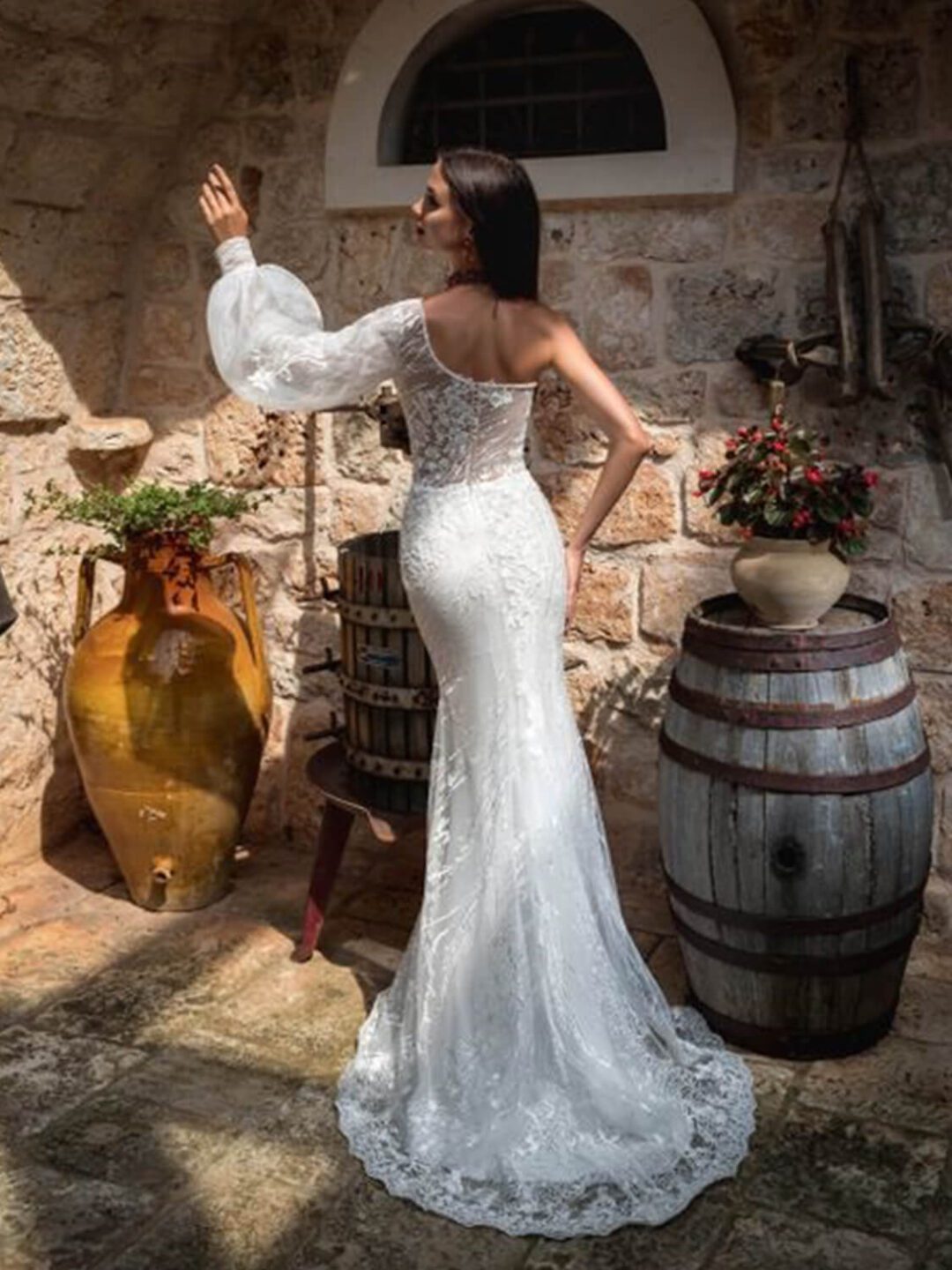 Γοργονέ νυφικό ολοκέντητο  με γαλλική δαντέλα και διαφάνεια soleil στο μπούστο, με έναν ώμο και φουσκωτό μανίκι δαντέλα. Φούστα γοργόνας με μακριά ουρά.