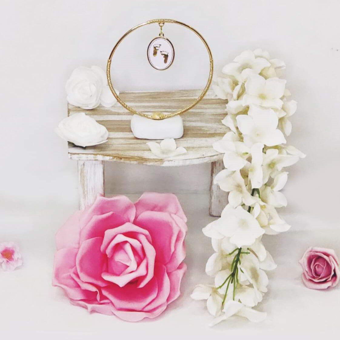 Μπομπονιέρα βάπτισης πετρούλα με μεγάλο μεταλλικό στεφάνι και διακοσμητικό στοιχείο με πατουσάκια