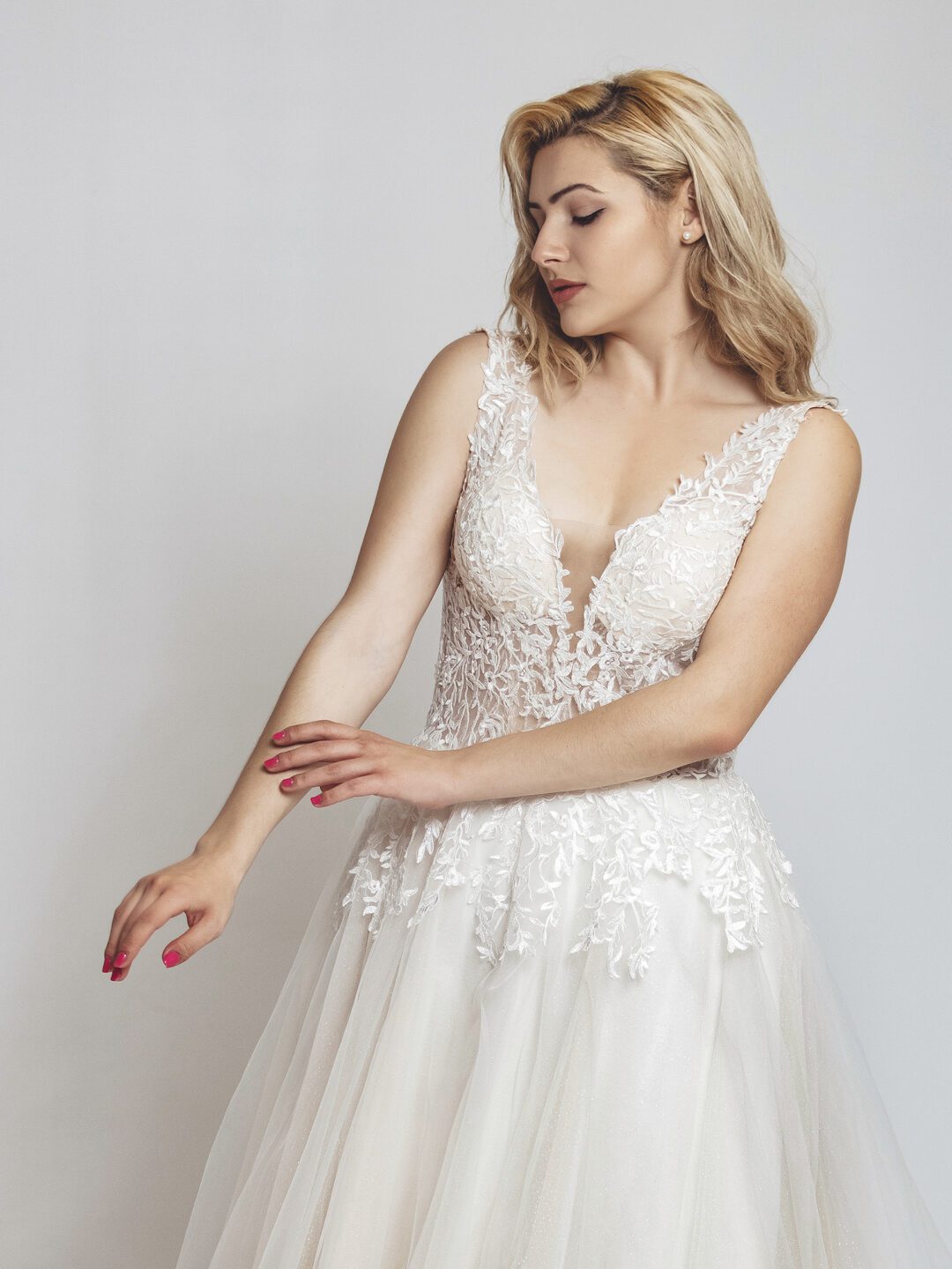 2E1A0189ηρετ Εντυπωσιακό νυφικό με διαφάνεια στο μπούστο και κεντημένο με ανάγλυφη γαλλική δαντέλα. Φούστα σε άλφα γραμμή, από γαλλικό τούλι σε λευκό με νερά στο χρώμα της πούδρας. Ανοιχτή πλάτη σε βαθύ V.