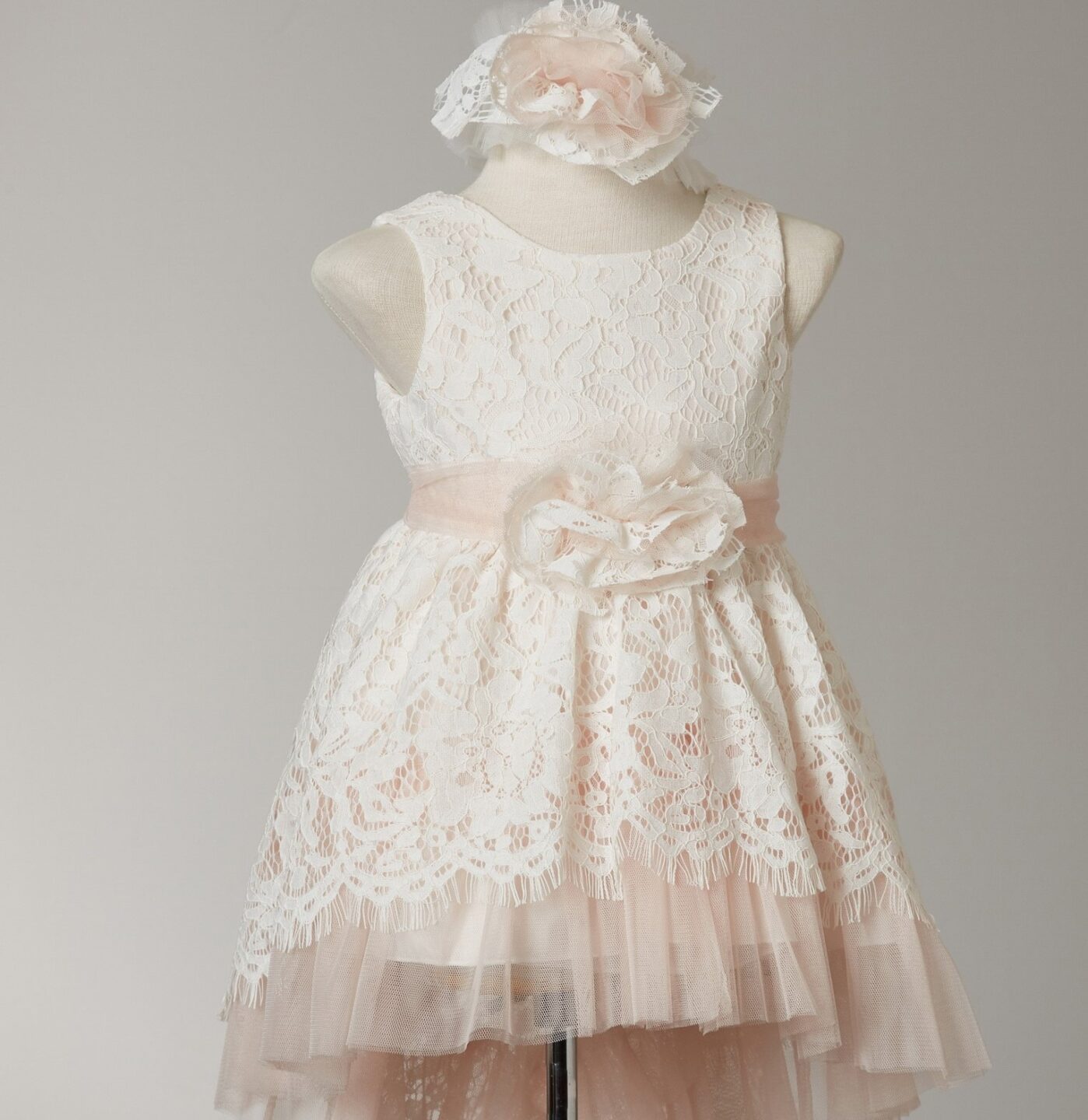 Ρομαντικό βαπτιστικό φόρεμα με ουρά, εκρού δαντέλα με πλούσιο τούλι εσωτερικά σε ελαφρύ σομόν. Συνδυάζετε με ίδια κορδέλα κεφαλιού. Ένα από τα πιο hot φορέματα βάπτισης που κερδίζει τις εντυπώσεις! Επωφελήσου από την προσφορά μας στο πλήρες σετ βάπτισης συνδυασμένο με ρούχο και παπούτσι και κέρδισε 15% έκπτωση σε όλα!