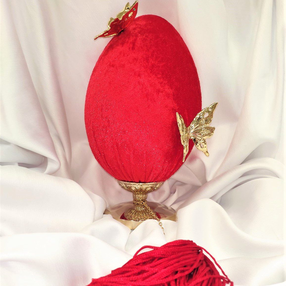 Διακοσμητικό αυγό σε κόκκινο βελούδο με επίχρυσες πεταλούδες