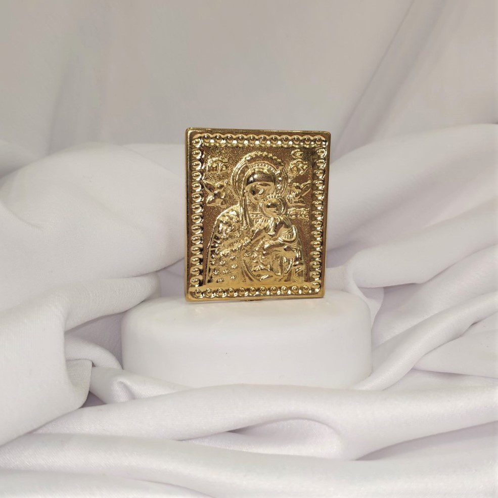 Μπομπονιέρα με λευκό βότσαλο και επίχρυσο διακοσμητικό με την Παναγία. Παραδίδεται έτοιμη δεμένη με κουφέτα. Διαστάσεις  ύψος 10εκ. πλάτος 8εκ. Ελάχιστη παραγγελία 20 τεμάχια.