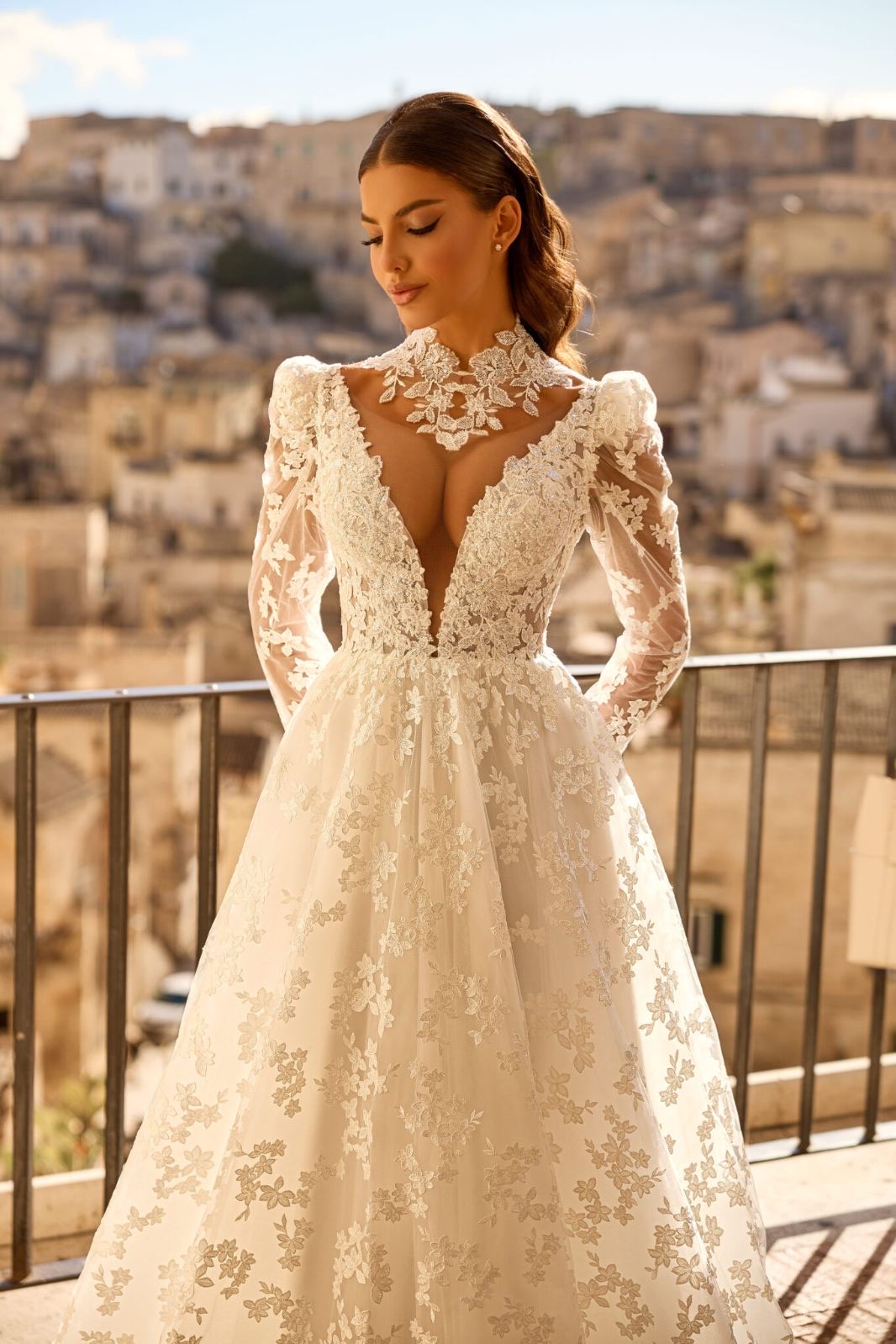 Νυφικό φόρεμα δαντέλα με βαθύ ντεκολτέ, μανίκια και ανοιχτή πλάτη.